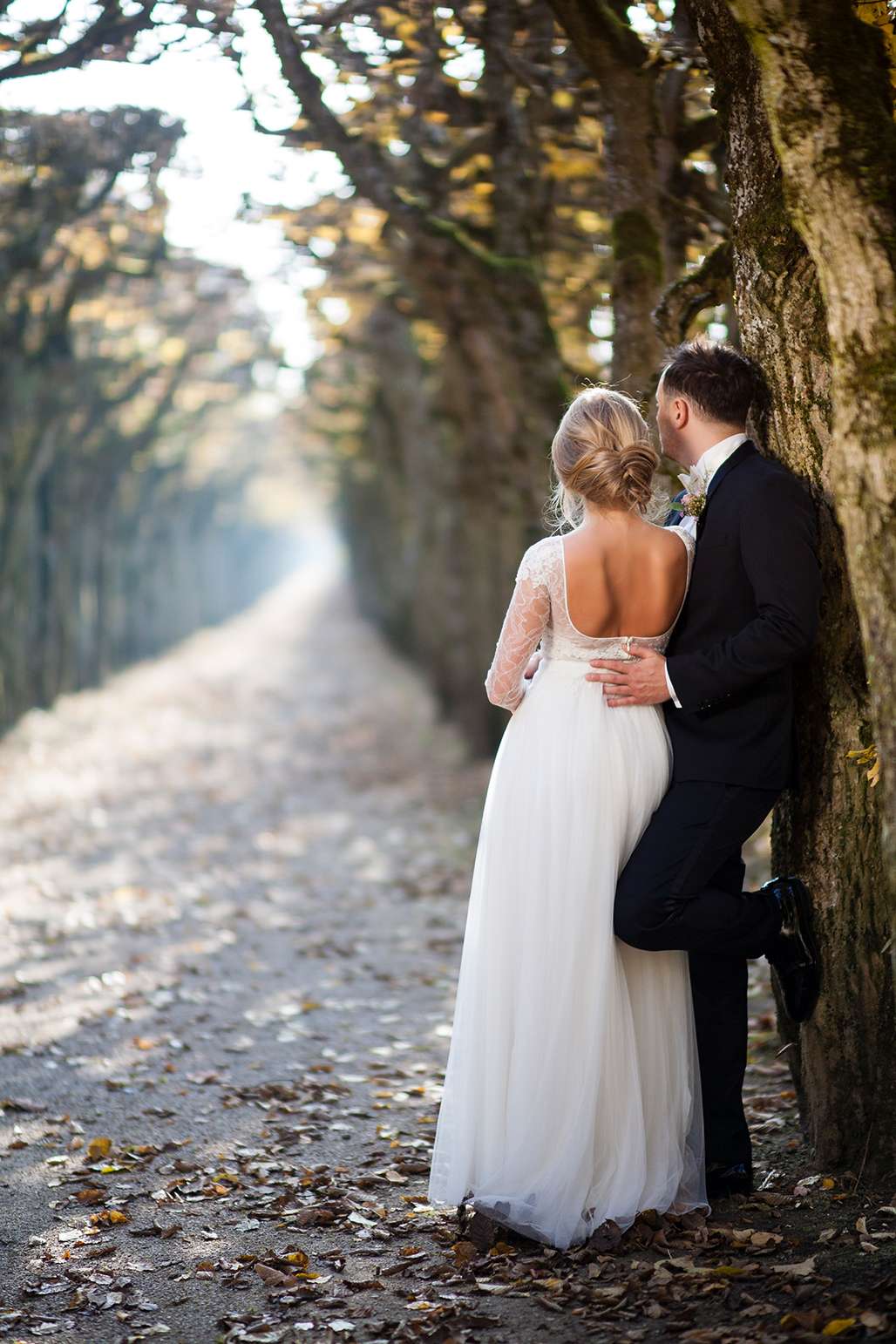 Detail des Brautkleids mit Spitzenärmeln und tiefem Rückenausschnitt bei Outdoor-Shooting.